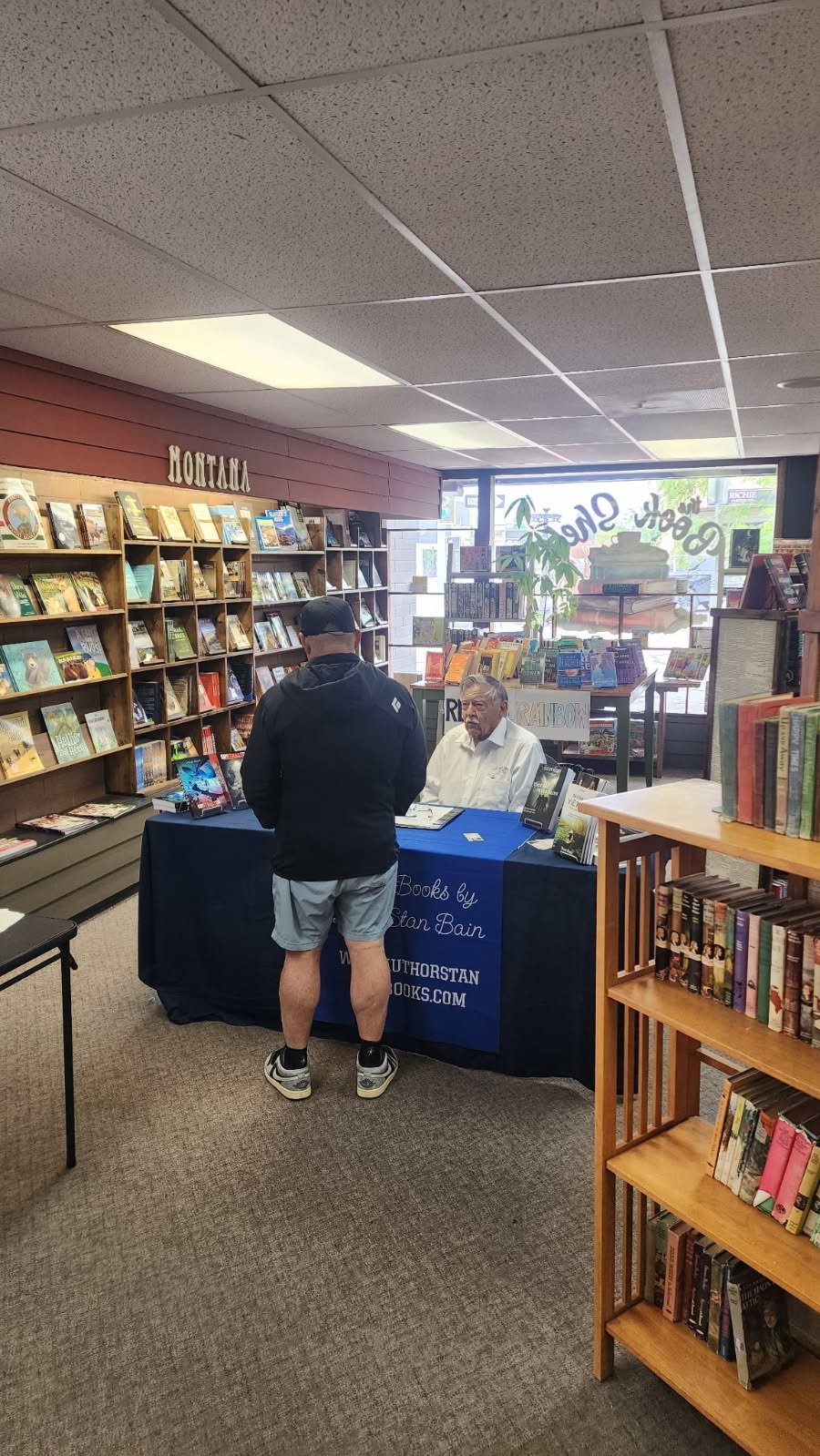 Stan Bain greeting a reader at his book signing table
